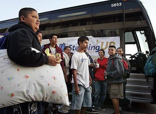With pillow in hand, Cesar Saucedo of Westminster prepares to leave on a bus with other low-income students from Orange County for a tour of Northern California colleges.
