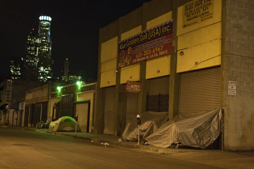 Homeless people's tents and tarps on Winston Street near San Pedro Street in downtown Los Angeles last February. The county's homeless population is up 16% over the last two years, according to a report released Friday.