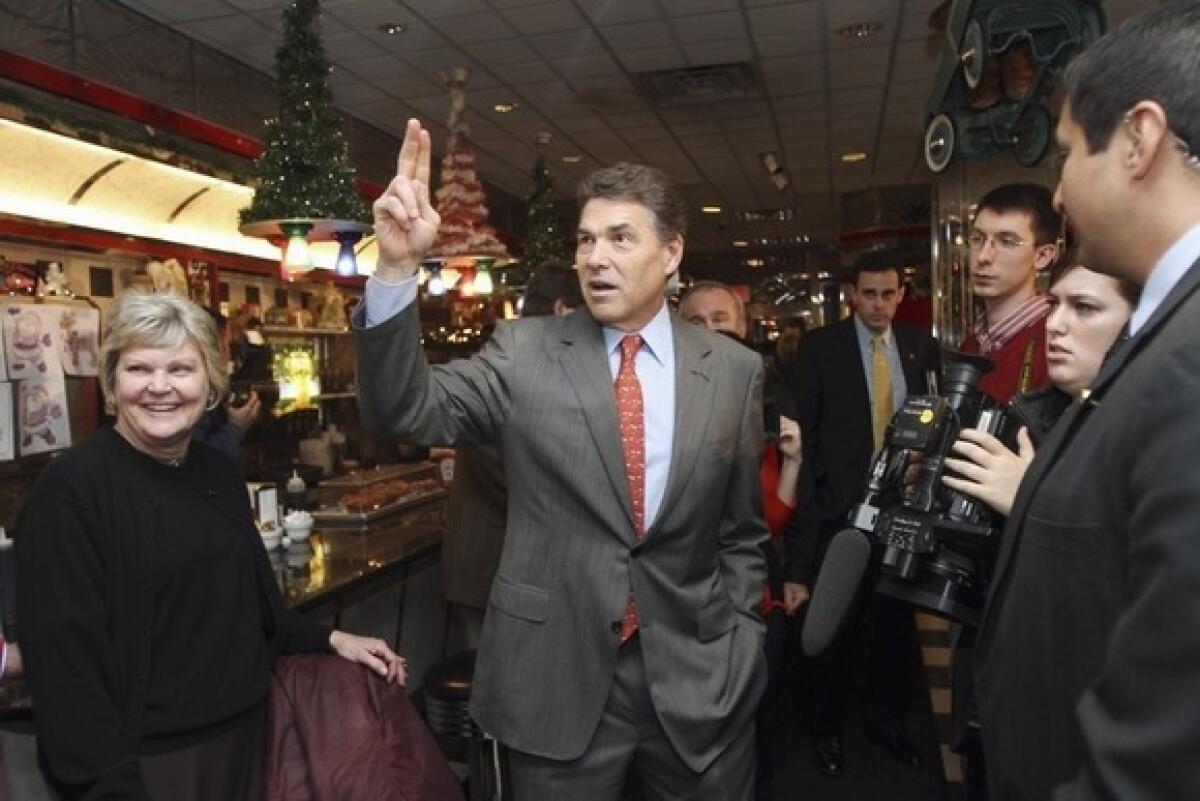 Rick Perry waves to supporters Tuesday during a campaign stop at Joey's Diner in Amherst, N.H.