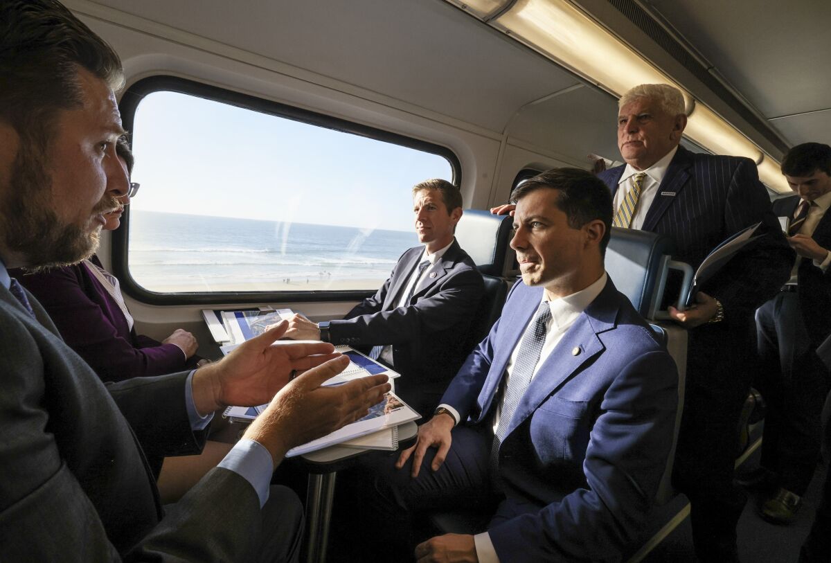 U.S. Transportation Secretary Pete Buttigieg (right) rides the NCTD Coaster in late October.