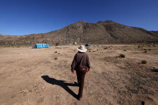 Sam Schultz stands near a portion of the U.S./Mexico border wall near Jacumba Hot Springs.
