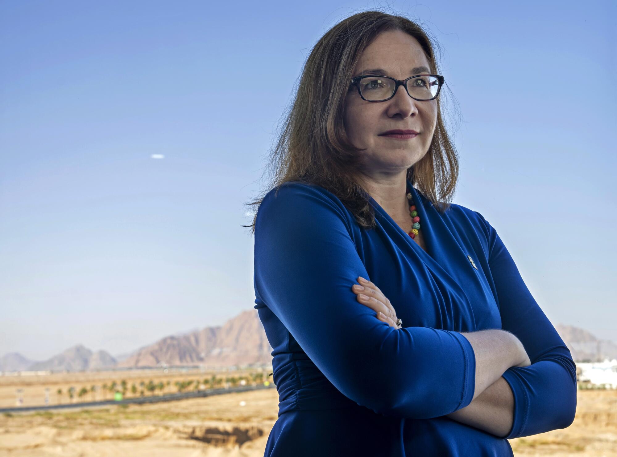 Katharine Hayhoe stands with folded arms.