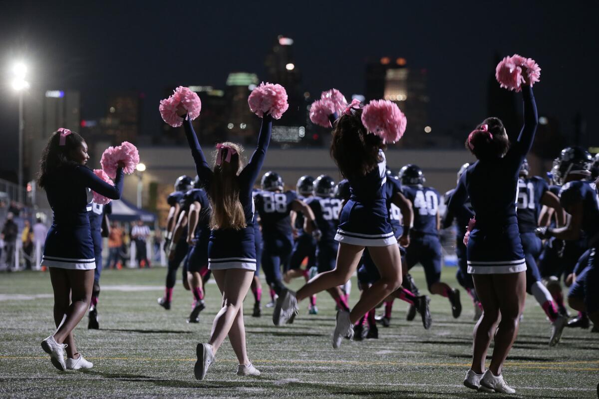 Loyola players take the field with the enthusiastic support of cheerleaders before taking on Chaminade at Loyola High School.