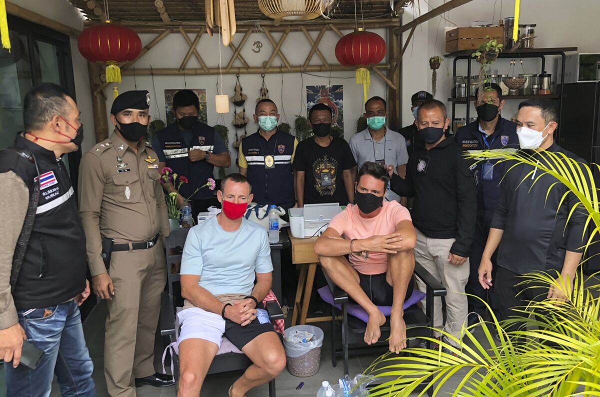 In this Tuesday, July 6, 2021, photo released by the Thai Immigration Police, immigration police arrest Alex Kartun, left, a dual German-Russian national, and Russian Victor Thubnikov, right, on Phangan island in southern Thailand. Kartun is one of two suspected leaders of a Germany-based drug gang who were arrested in southern Thailand on Tuesday at the request of German authorities, while his companion, Thubnikov, was arrested for possession of marijuana. (Thai Immigration Police via AP)
