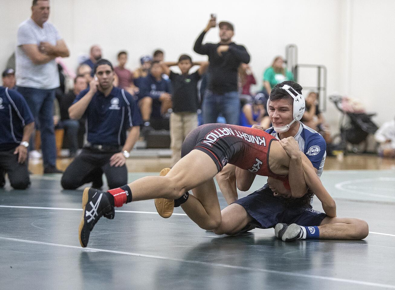 Newport Harbor's Edwin Leon wrestles against Katella's Adam Martinez in the 120 weight class during the Costa 4-Way Duals at Costa Mesa High School on Thursday, November 29.
