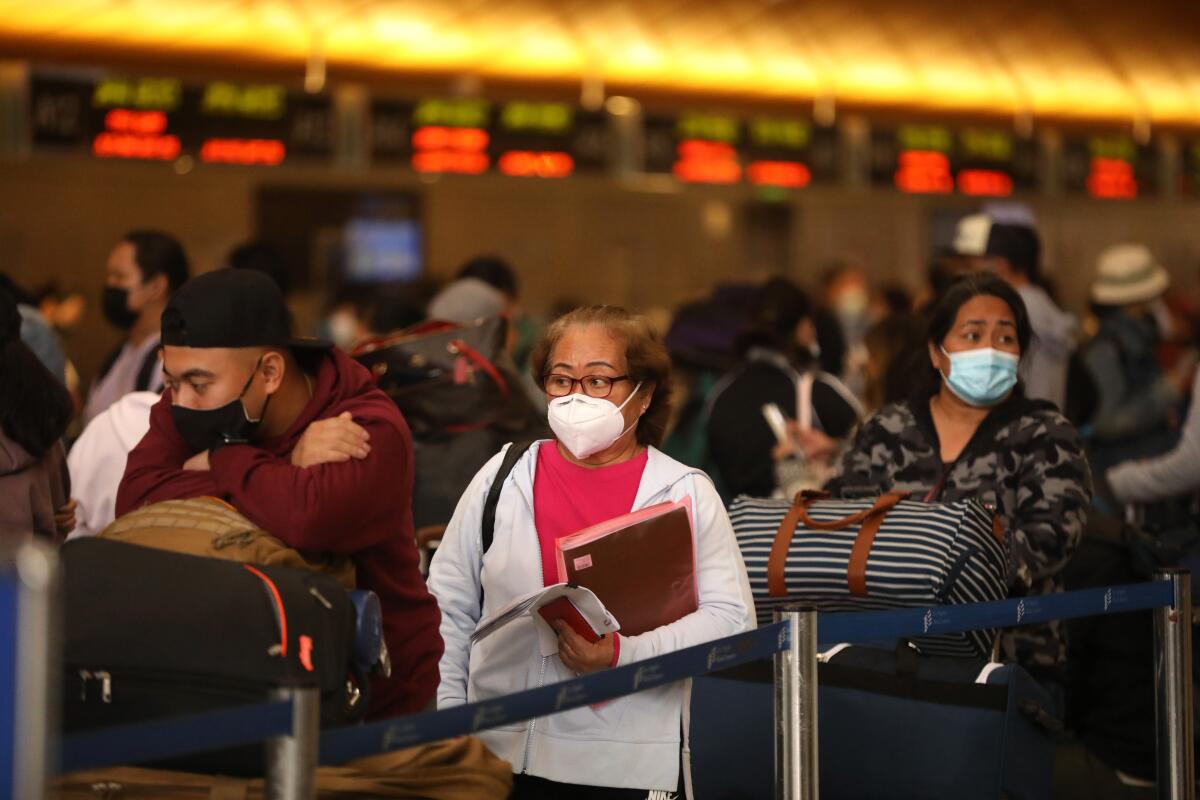 Masked travelers waiting in line at LAX.