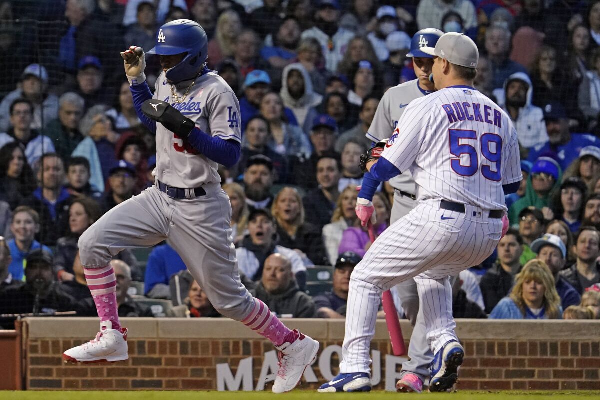 The Dodgers' Mookie Betts scores on a wild pitch by Cubs relief pitcher Michael Rucker 
