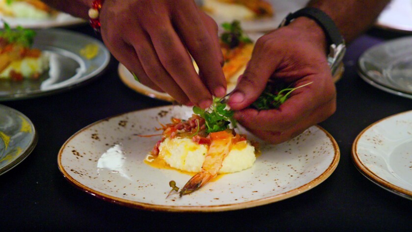 A pair of hands arranges a plate of food.