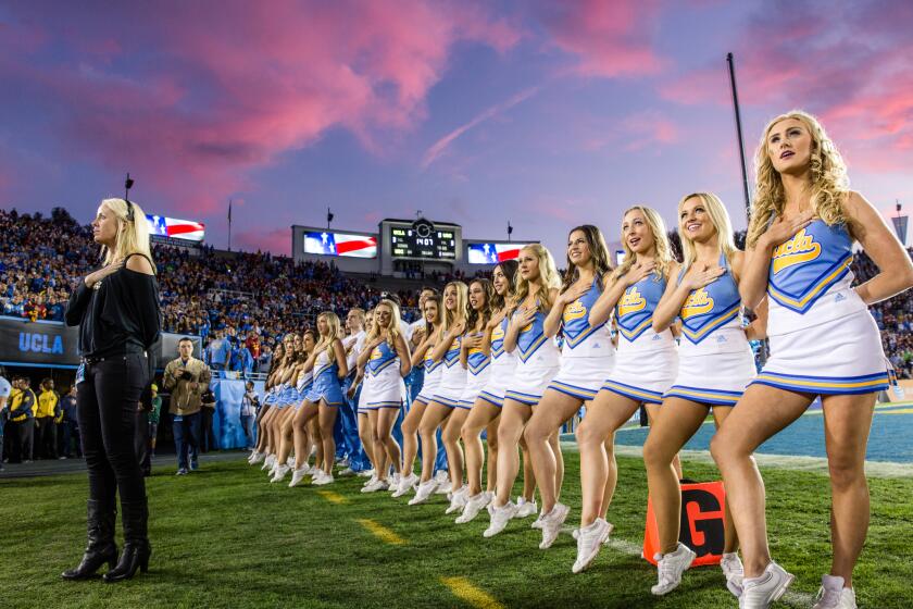 Director Mollie Vehling leads the UCLA Spirit Squad during the playing of the National Anthem.