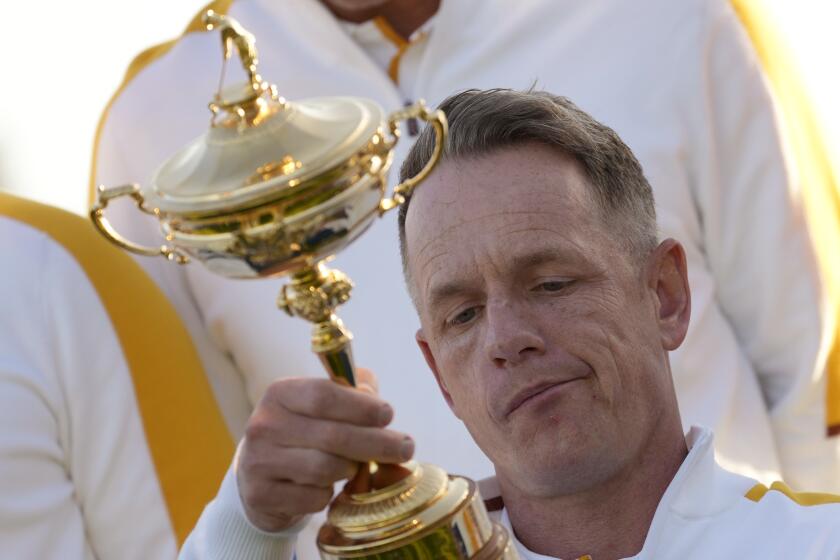 Europe's Team Captain Luke Donald holds and looks at the list of winner engraved on the Ryder Cup trophy as his team pose for the team photo at the Marco Simone Golf Club in Guidonia Montecelio, Italy, Tuesday, Sept. 26, 2023. The Ryder Cup starts Sept. 29, at the Marco Simone Golf Club. (AP Photo/Gregorio Borgia)