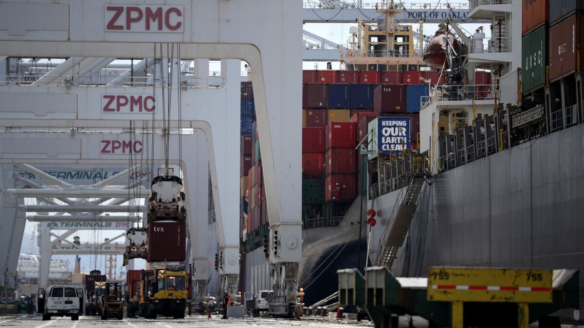 Containers are offloaded from a ship docked at the Port of Oakland in Oakland, Calif., on May 13.