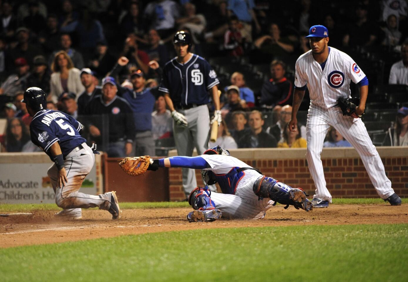 The Padres' Alexi Amarista scores as John Baker makes a late tag during the ninth inning.