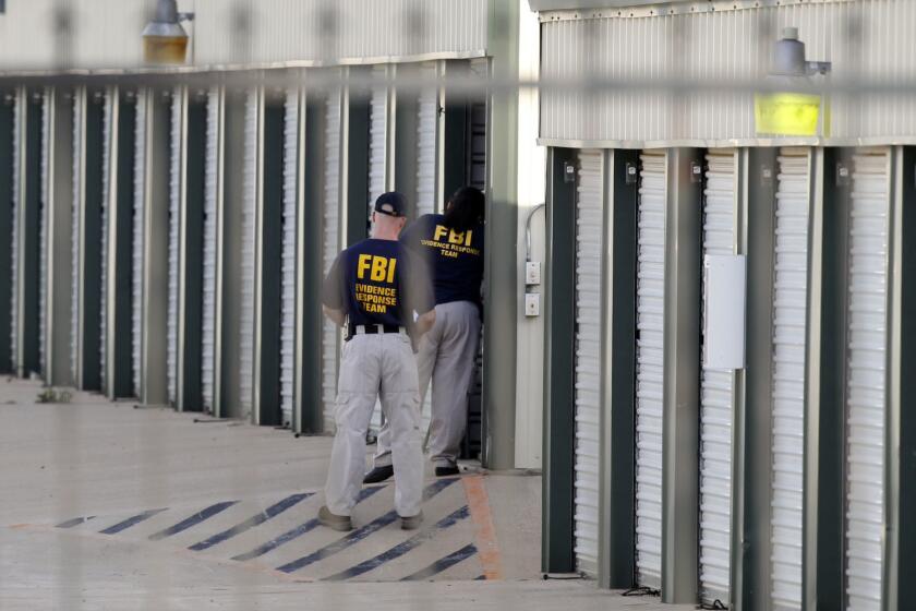 Authorities search a storage unit at Gibson Self Storage on Saturday as they continue to investigate the slayings of Kaufman County Dist. Atty. Mike McLelland, his wife and another top prosecutor in Texas.