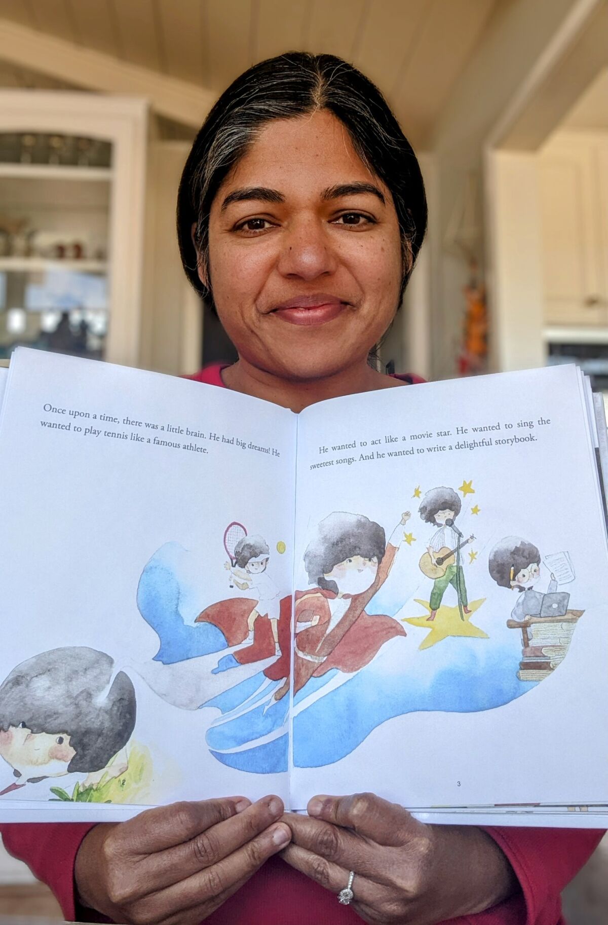 Author Jyoti Mishra showing the illustrations by Grace Wiguna for her children's book "The Little Brain".