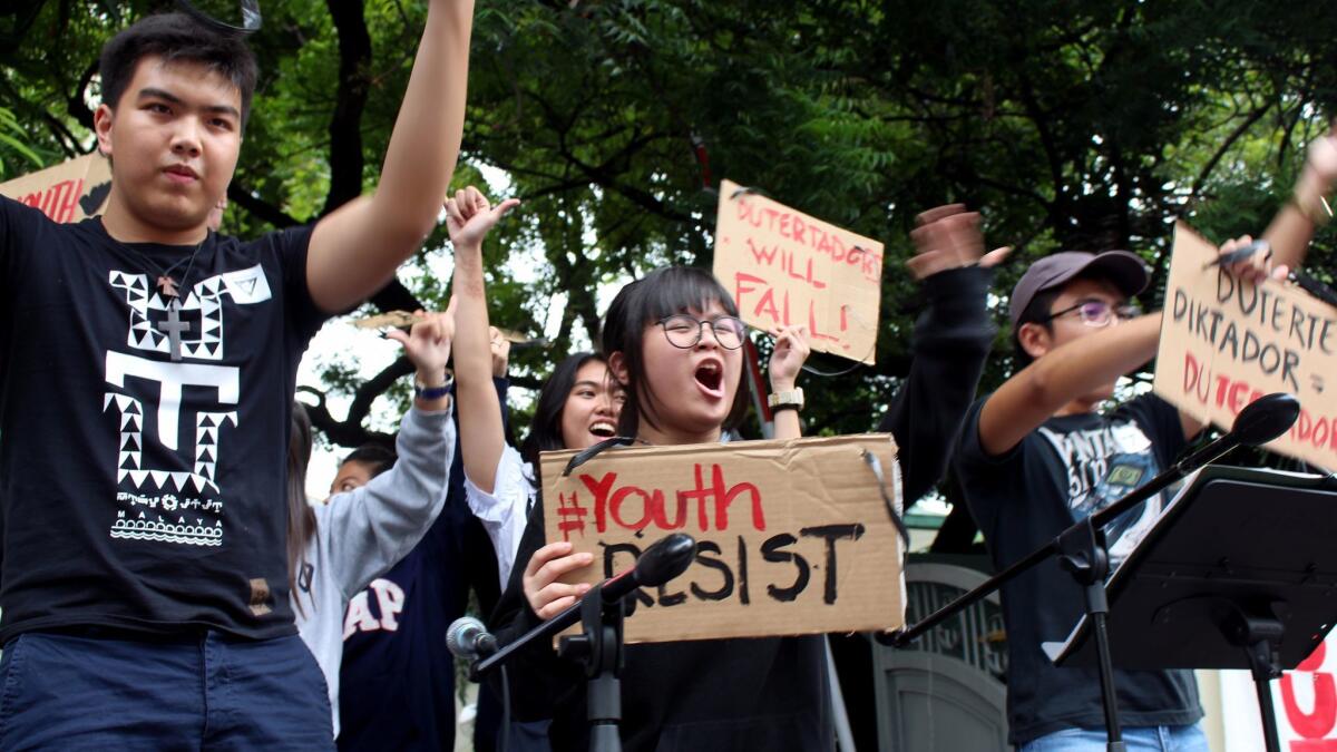 Shibby de Guzman, 13, center, joins other youths Tuesday at a Manila rally to protest policies of the Duterte government.