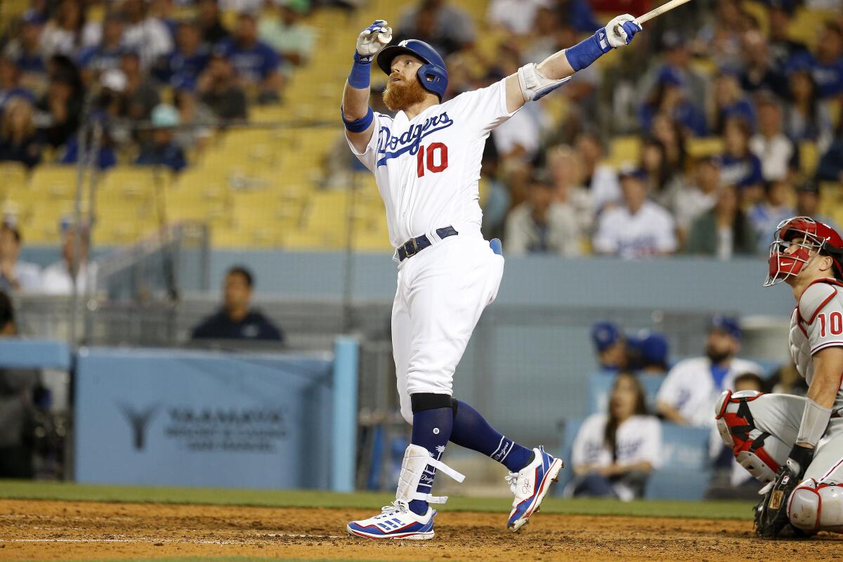 Dodgers designated hitter Justin Turner hits the ball and watches it launch.