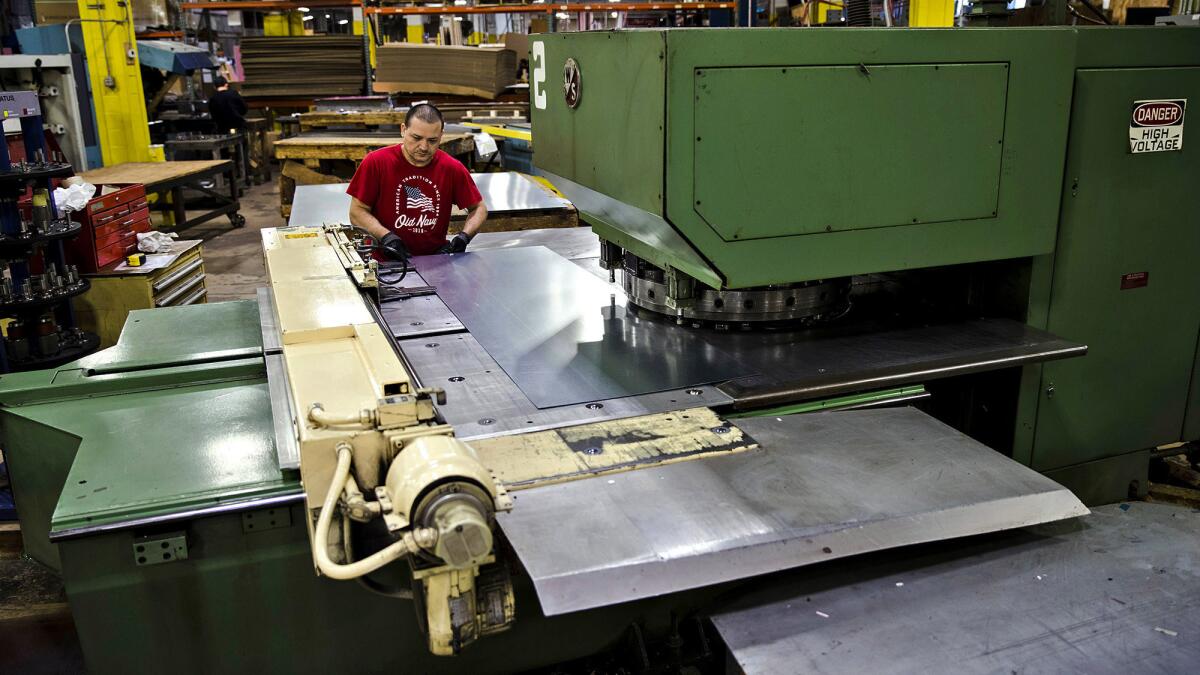 Jose Hernandez operates a turret press at a commercial refrigeration manufacturing facility in Philadelphia in October.
