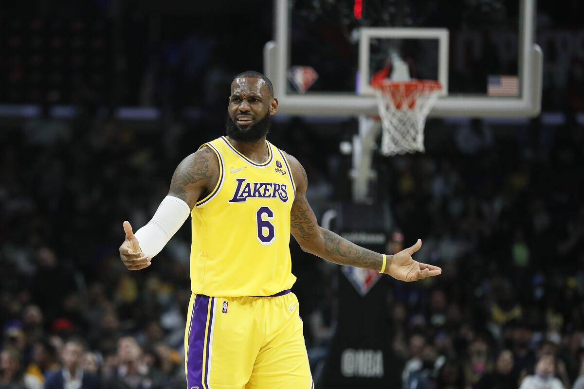 Lakers star LeBron James holds his arms out and grimaces in reaction to a call during a game.