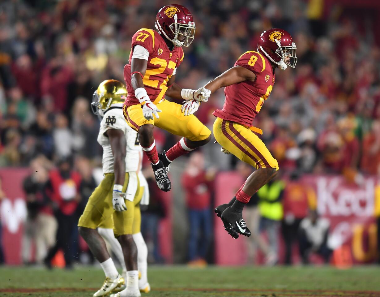 USC defenders Ajene Harris (27) and Iman Marshall celebrate after stopping Notre Dame on fourth down in the second quarter at the Coliseum Saturday.