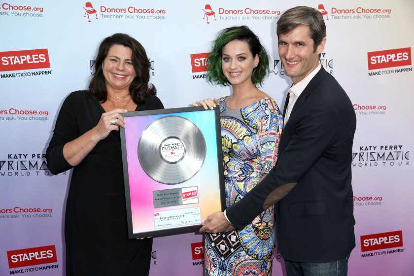 Katy Perry, center, joins Alison Corcoran, senior vice president of marketing for Staples, on June 12 to present DonorsChoose.com's founder and Chief Executive Charles Best with a commemorative platinum record celebrating Staples' $1-million donation as part of the Make Roar Happen campaign.