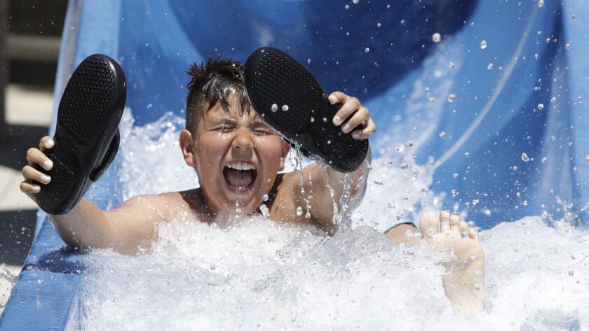 Angel Escobedo, 11, knows how to beat the heat: With a ride down the water slide at Splash Zone in Rosemead.