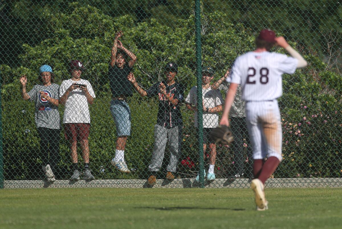 Youngster fans in the outfield cheer on Laguna Beach's Lucien Reed (28) after the Breakers scored two runs against Norco.