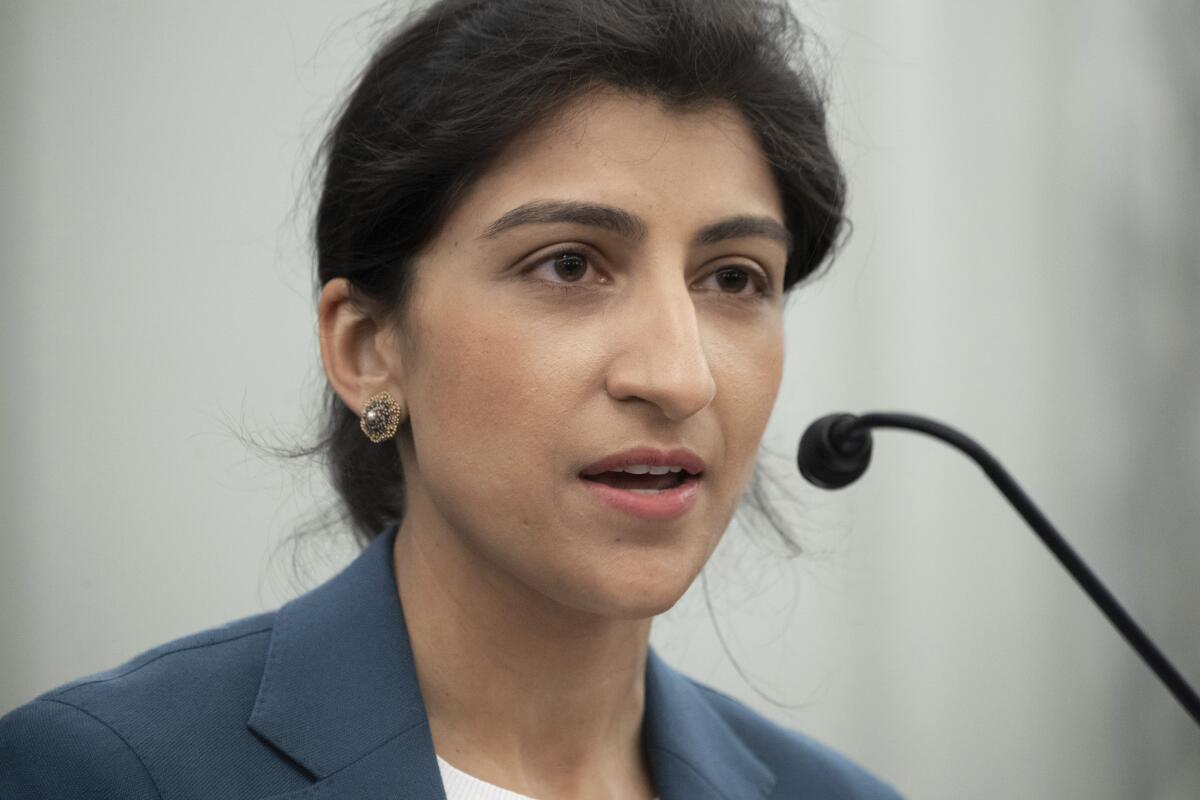 Lina Khan speaks into a microphone