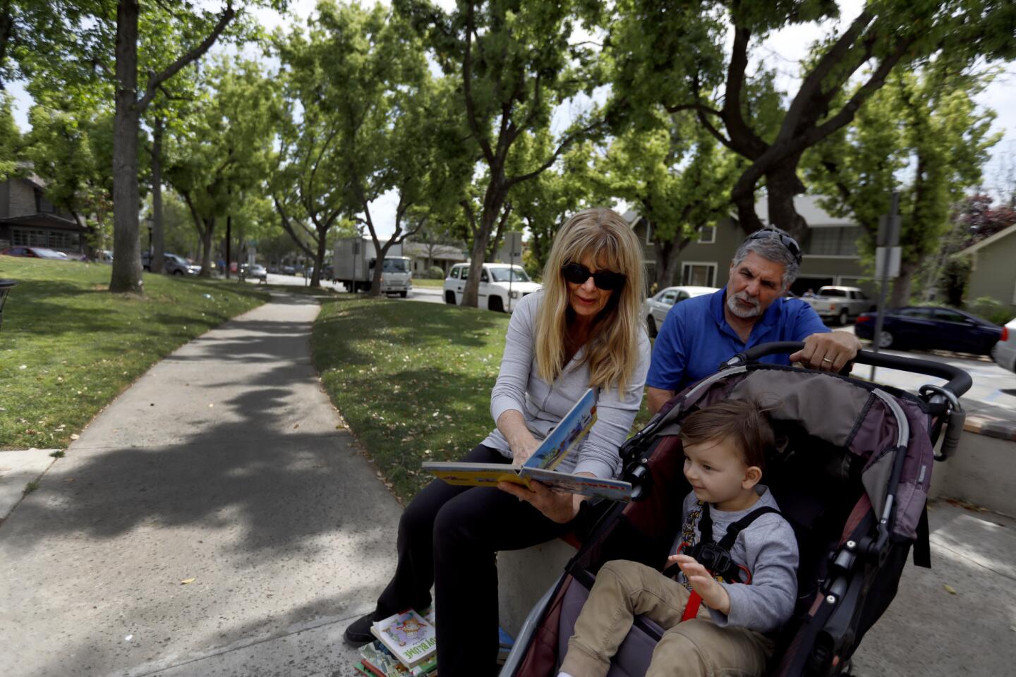 SOUTH PASADENA, CA APRIL 11, 2019: Cindy Ringo and Gary Ringo both of Riverside read to their grandson Jovian Greenhouse, 3, of South Pasadena, as they sit outside South Pasadena Public Library in South Pasadena CA April 11, 2019. (Francine Orr/ Los Angeles Times)