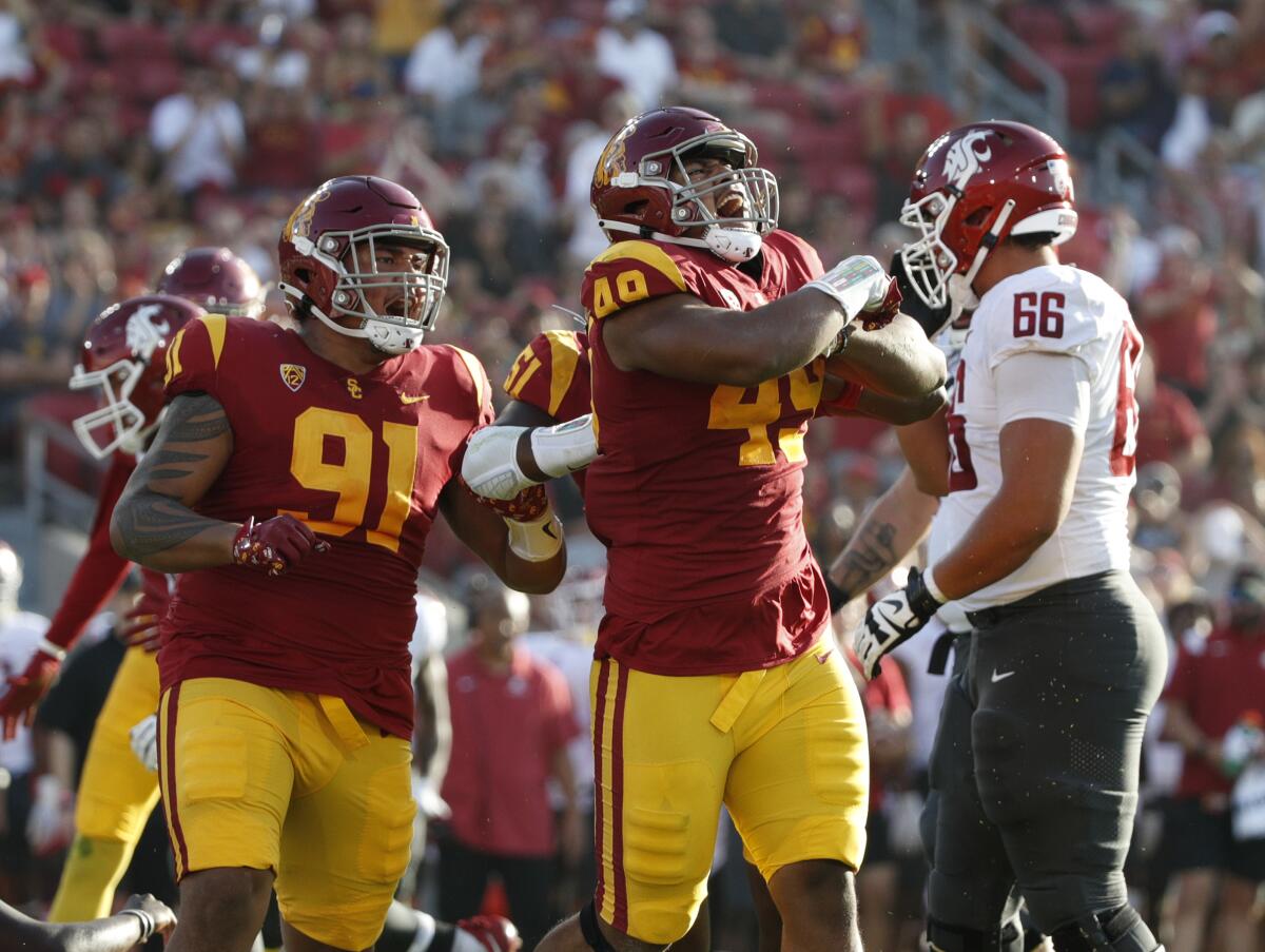 USC defensive lineman Tuli Tuipulotu celebrates after a tackle