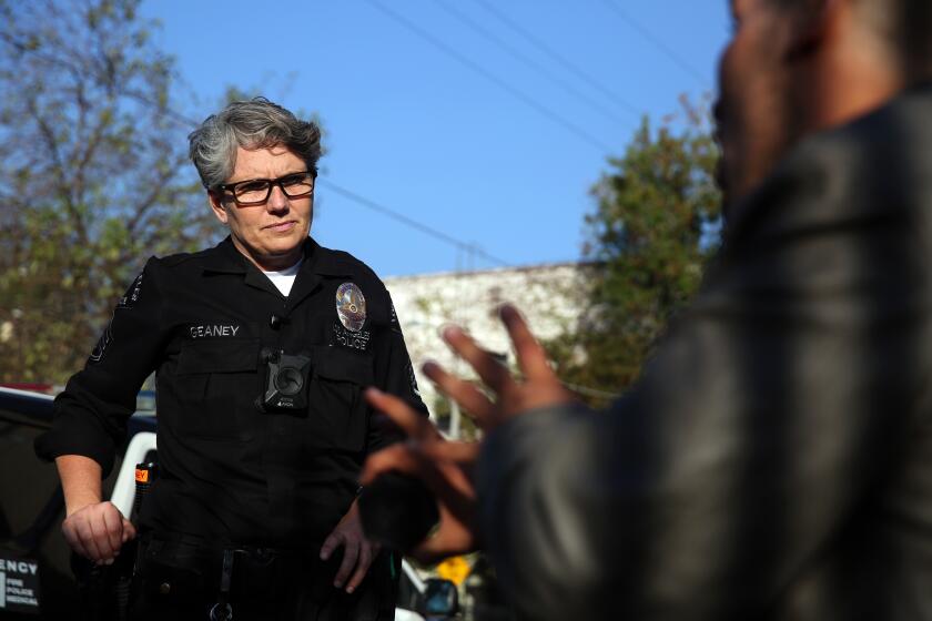 LOS ANGELES, CA-OCTOBER 29, 2019: LAPD Sgt. Shannon Geaney checks in on Drew Blair who has been staying on the corner of Tamarind and Carlos Ave. in Hollywood for about a month on October 29, 2019 in Los Angeles, California. Many of the residents in the area have said they witnessed domestic violence, drug dealing, psychotic breakdowns and have been afraid to leave their homes. (Photo By Dania Maxwell / Los Angeles Times)