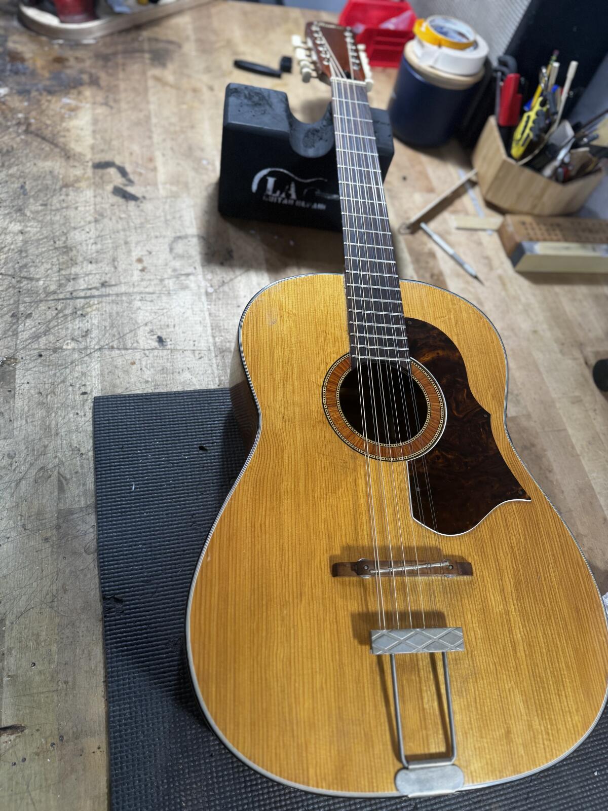 A guitar lies on a workbench