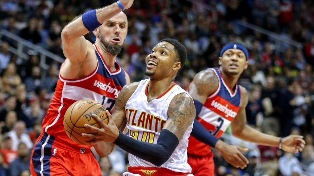 Hawks guard Kent Bazemore drives down the lane against Wizards center Marcin Gortat in the second half Saturday.