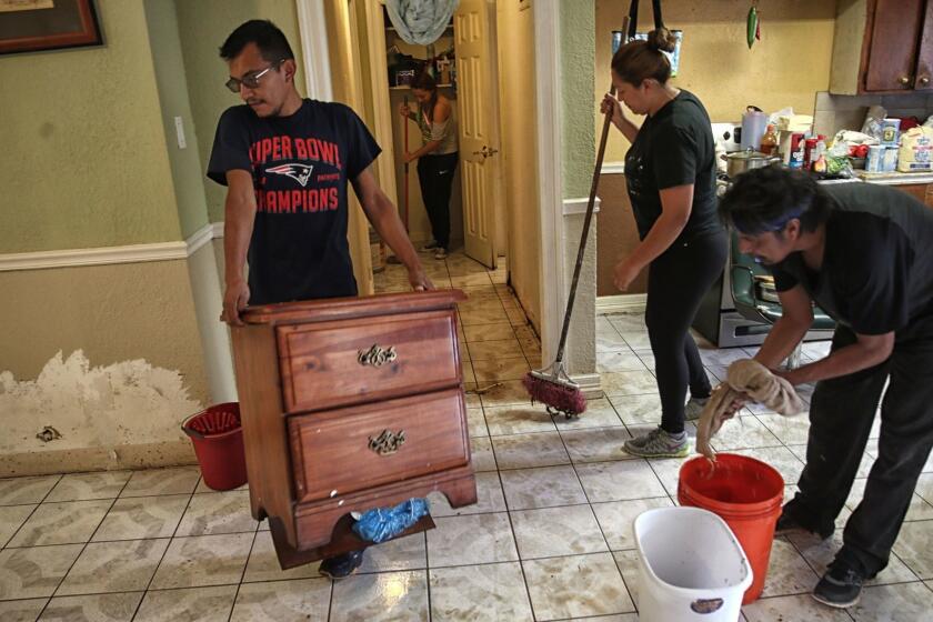 HOUSTON, TEXAS, WEDNESDAY, AUGUST 30, 2017 - Juan Figueroa removes damaged furniture from his mother's Northeast Houston home where residents begin rebuilding from the devastating effects of Hurricane Harvey. (Robert Gauthier/Los Angeles Times)