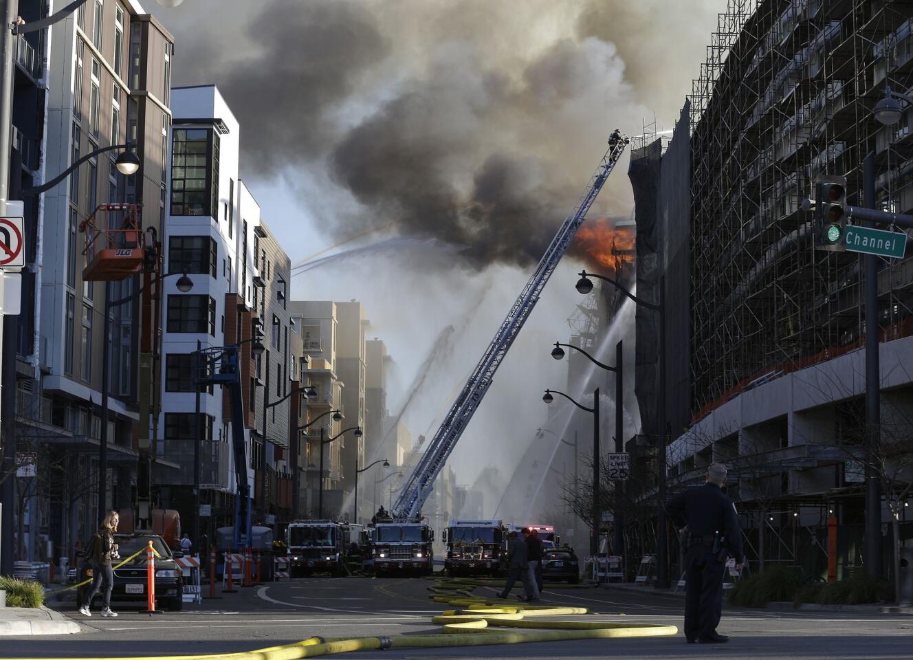 Firefighters battle a fire that began in a condo high-rise under construction in the Mission Bay area of San Francisco near At&T Park. One firefighter was injured, authorities said.