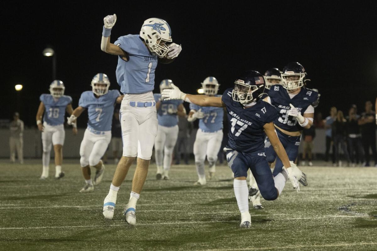 Corona del Mar's Cooper Hoch, left, avoids a tackle by Newport Harbor's Tony Glynn during Friday night's game.