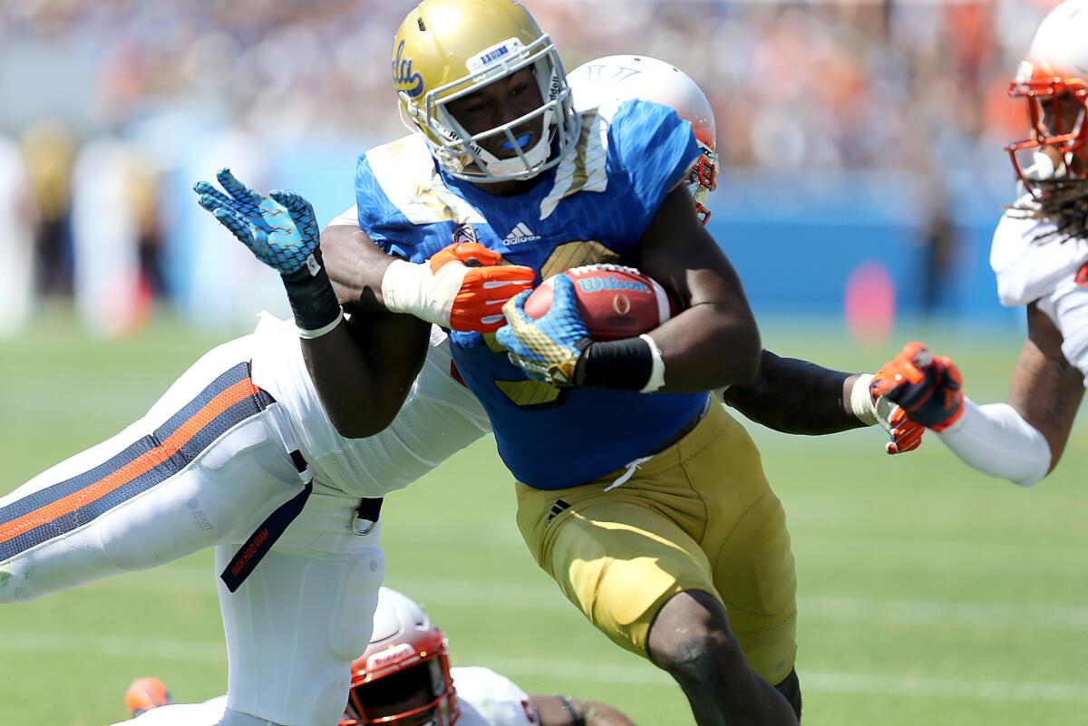 UCLA linebacker Myles Jack powers the ball down to the Virginia one-yard line in the second half of the season opener, moments before scoring a touchdown.