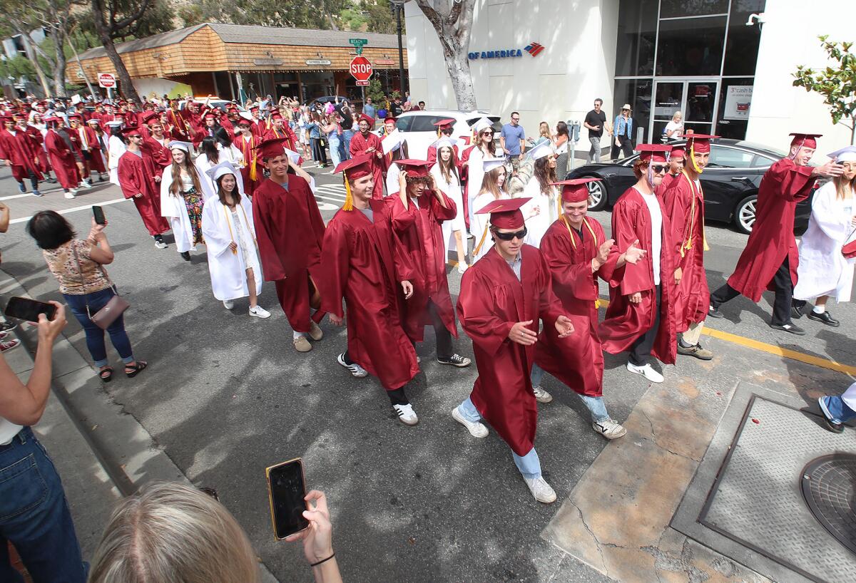 Laguna Beach High graduates celebrate via the "grad walk" down Ocean Avenue toward Main Beach Park on Wednesday.