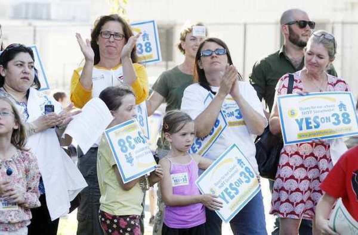 Attendees applaud in support of the comments made at Olive Park in Burbank where PTA members, local teachers, parents and community leaders rallied Tuesday for Proposition 38 which would guarantee $77 million for Burbank schools for the next 12 years.