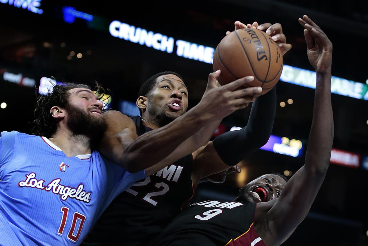 Clippers center Spencer Hawes battles Heat forwards Danny Granger, center, and Luol Deng for a rebound Sunday at Staples Center.