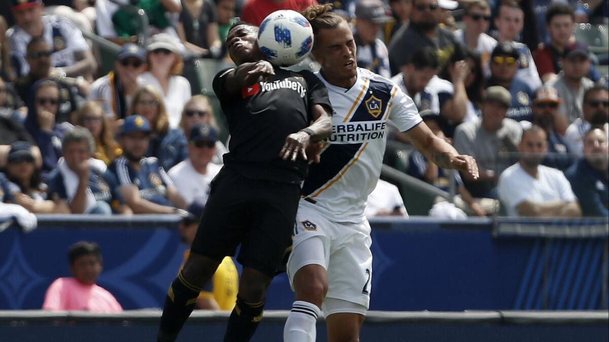 LAFC forward Latif Blessing, left, and Galaxy defenseman Rolf Feltscher battle for control of the ball in the first half on Mar. 31 at StubHub Center in Carson. The Galaxy came from behind to win 4-3.