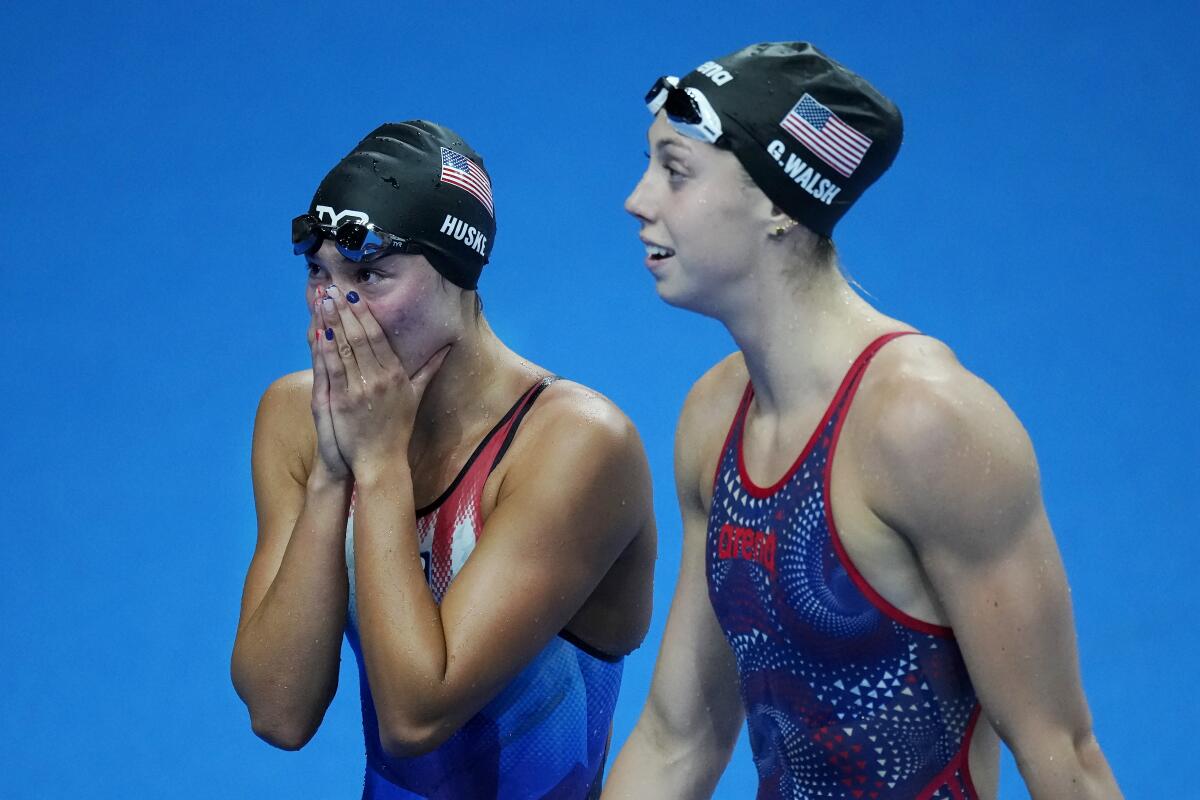 Torri Huske, left, of the United States, reacts after winning the women's 100-meter butterfly final 