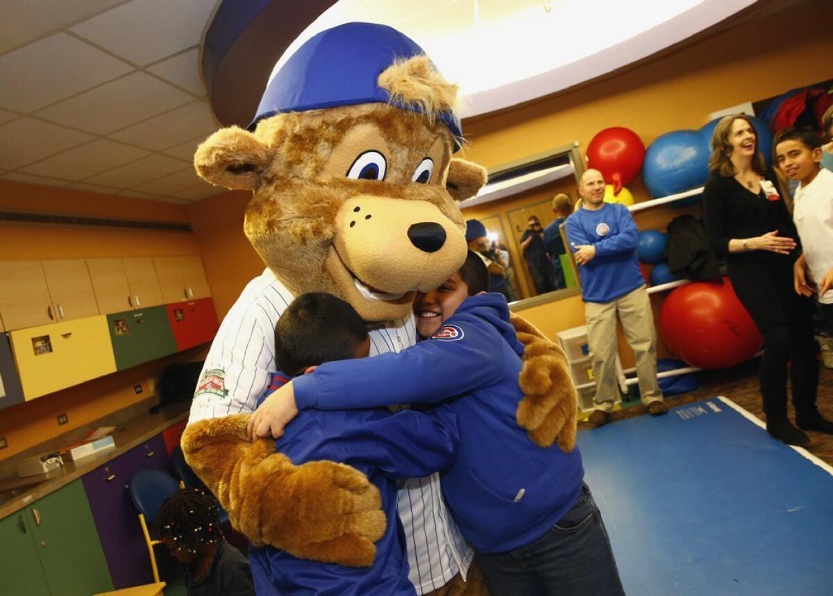 Clark the Bear, the Chicago Cubs' first mascot, hugs children during his debut.