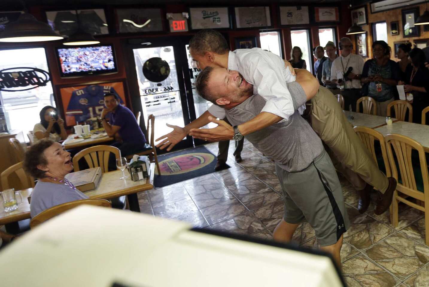 President Obama is lifted off the ground by restaurant owner Scott Van Duzer during a visit to Duzer's Big Apple Pizza in Fort Pierce, Fla.