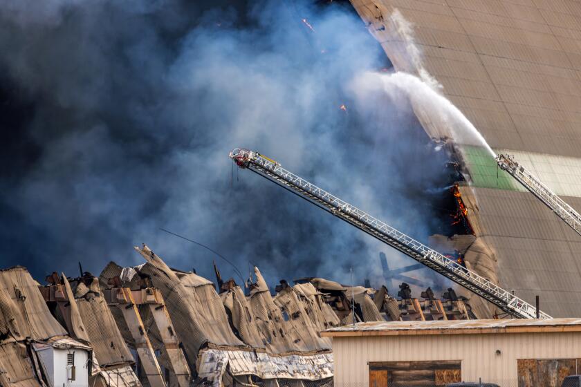 TUSTIN, CA - NOVEMBER 07: A stubborn fire at hangars at the former Tustin Air Base burns Warner Avenue and Legacy on Tuesday, Nov. 7, 2023 in Tustin, CA. (Irfan Khan / Los Angeles Times)