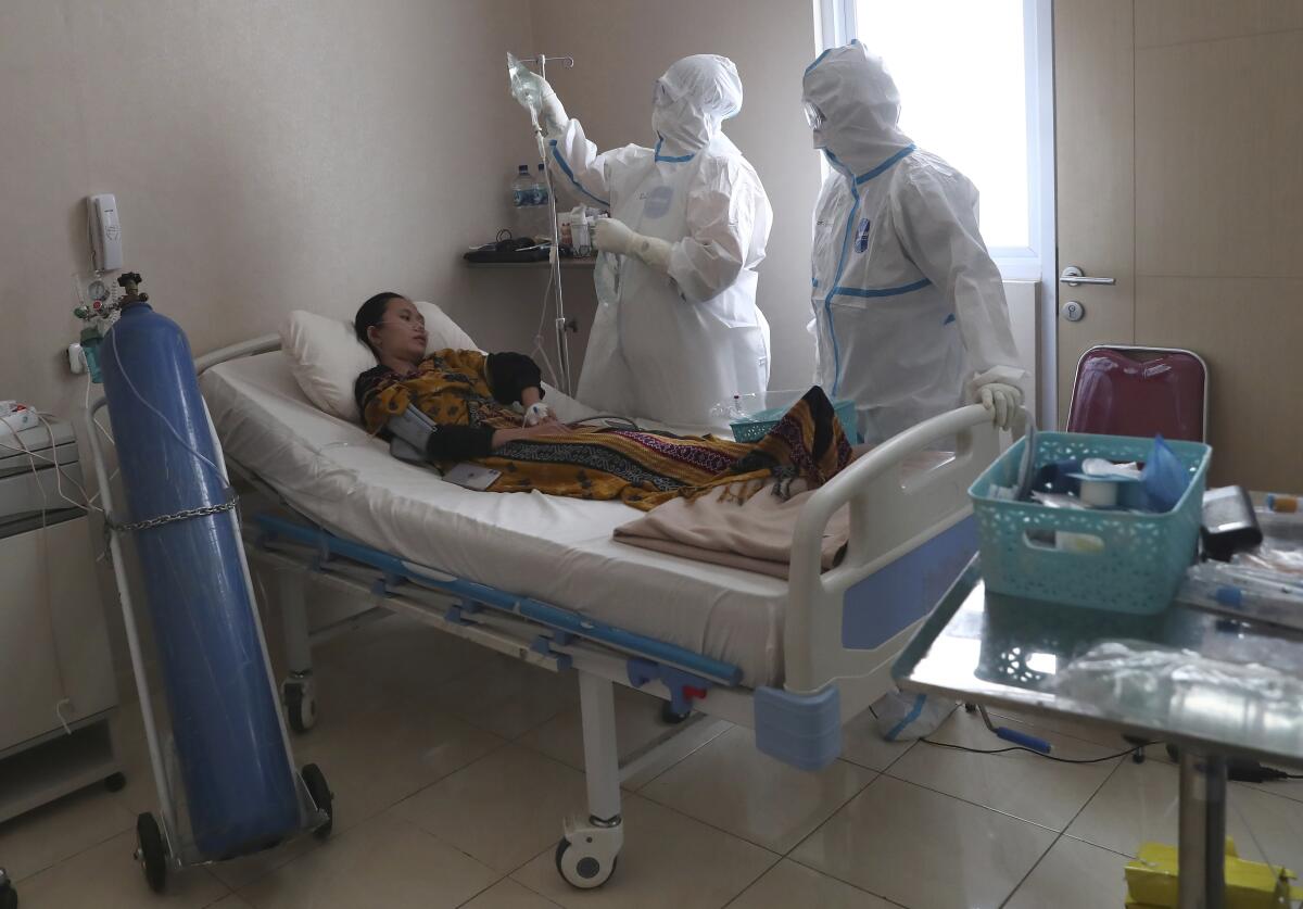 Trabajadores de la salud atienden a un enfermo con COVID-19 en el Hospital General Dr. Suyoto en Yakarta, Indonesia
