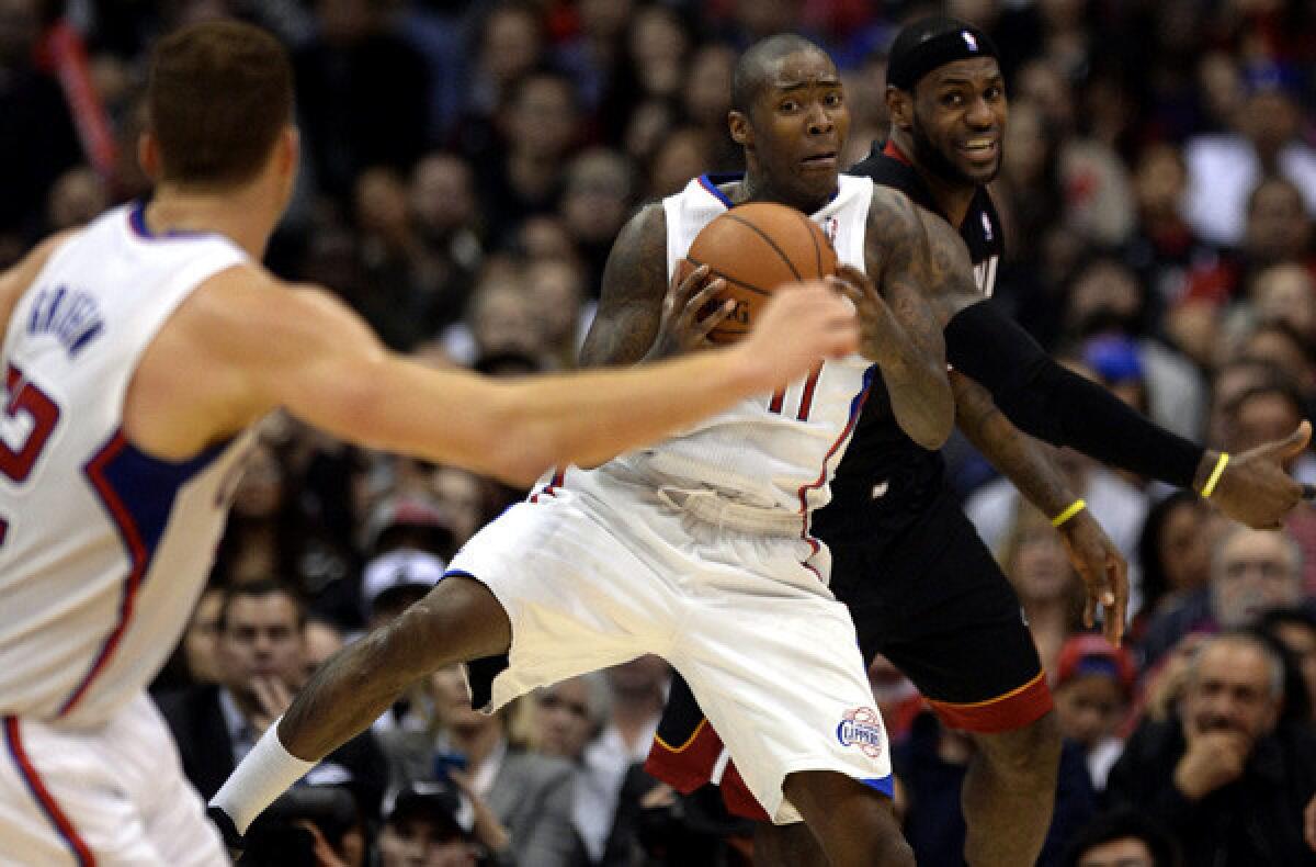 Clippers guard Jamal Crawford pulls down a rebound in front of Heat forward LeBron James as teammate Blake Griffin looks for an outlet pass during their game Wednesday at Staples Center.