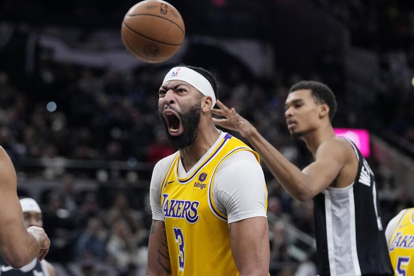 Los Angeles Lakers forward Anthony Davis (3) reacts after scoring over San Antonio Spurs center Victor Wembanyama (1) during the first half of an NBA basketball game in San Antonio, Wednesday, Dec. 13, 2023. (AP Photo/Eric Gay)