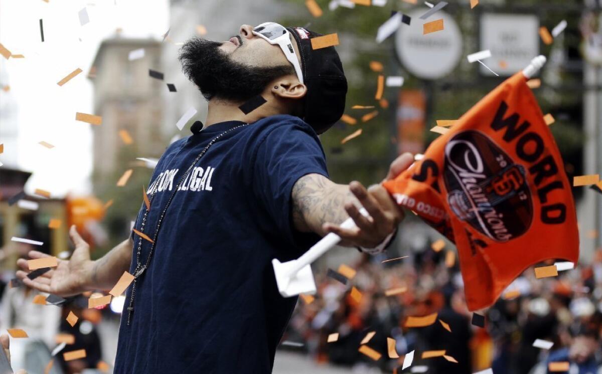 San Francisco Giants pitcher Sergio Romo looks up as confetti falls during the baseball team's World Series victory parade in San Francisco.