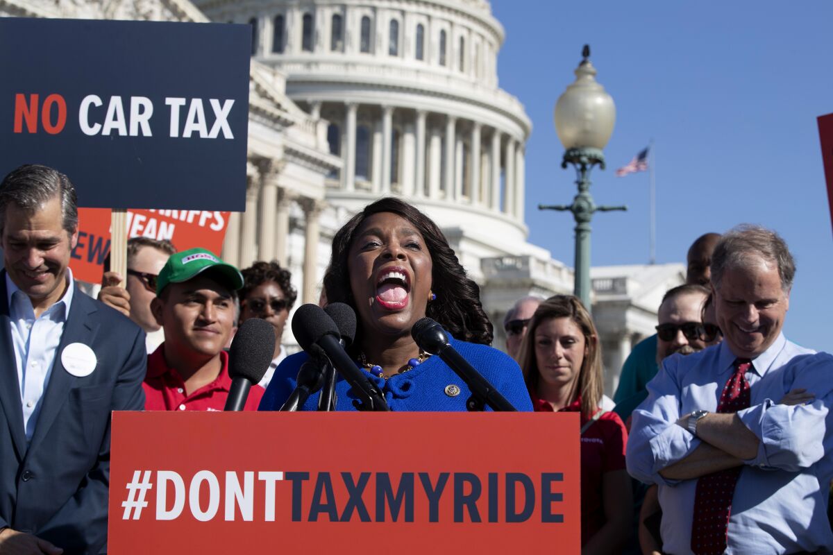 FILE - Rep. Terri Sewell, D-Ala., center, joined by Sen. Doug Jones, D-Ala., right, speaks out against trade tariffs that could negatively impact U.S. auto manufacturing. on Capitol Hill in Washington, July 19, 2018. The Democratic congresswoman’s journey from rural Selma to the halls of Congress offers a vivid portrait of the progress the United States has made toward ending voter discrimination, but also of the accumulating setbacks in the long campaign for voting rights. (AP Photo/J. Scott Applewhite, File)