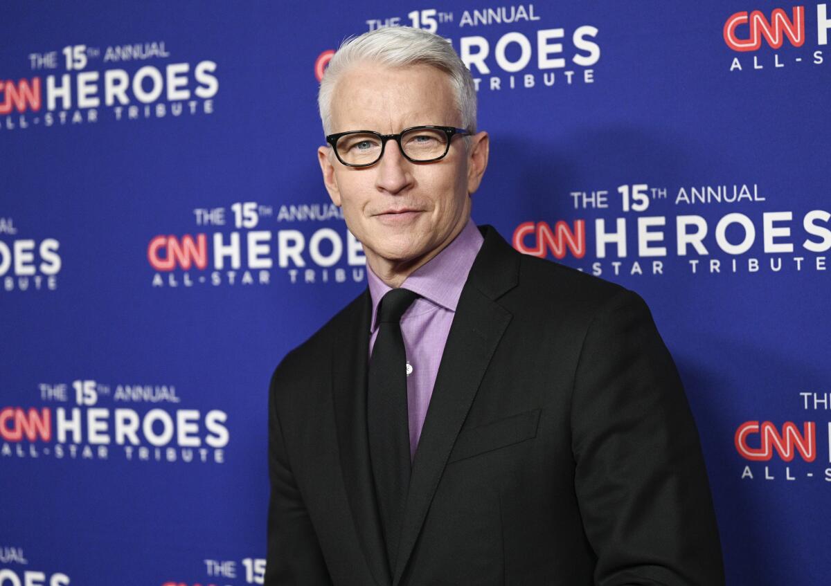 A man with white hair wearing glasses and a suit